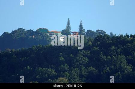 Una vista panoramica delle case su una collina ricoperta di verdi foreste Foto Stock