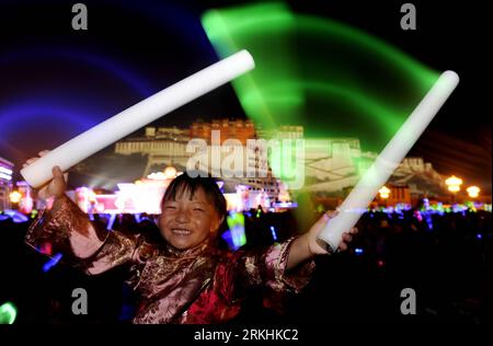 Bildnummer: 55848448 Datum: 29.08.2011 Copyright: imago/Xinhua (110830) -- LHASA, ago. 30, 2011 (Xinhua) -- Una ragazza del gruppo etnico tibetano onde bagliore bastoni per celebrare il Festival di Shoton vicino al Potala Palace a Lhasa, capitale della regione autonoma del Tibet della Cina sud-occidentale, 29 agosto 2011. Il festival di Shoton, che letteralmente significa festival del banchetto dello yogurt, è uno dei festival più importanti per i tibetani. La data esatta dello Shoton Festival non è fissata, anche se quasi sempre cade in agosto. (Xinhua/Purbu Zhaxi) (lfj) CHINA-LHASA-SHOTON FESTIVAL-PERFORMANCE (CN) PUBLICATIONxNOTxINxCHN Gesellsch Foto Stock