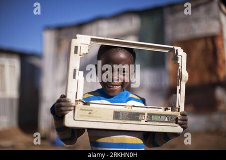 Bildnummer: 55877913  Datum: 24.08.2011  Copyright: imago/Xinhua (110901) -- JOHANNESBURG , Sept. 01, 2011 (Xinhua) -- 5-year-old Phelo poses with a cover plate of an electric equipment he found in trash, in Motswaledi Informal settlement of Soweto, Johannesburg, South Africa, Aug. 24, 2011. Children in the shanty towns don t have fancy toys like transformers, barbies or remote control airplanes, but they have a lot of fun playing with a piece of wire, a ball, a discarded circuit board or even a piece of paper. These so-called toys bring happiness to the children, though heart-breaking it may Stock Photo