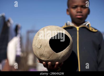 Bildnummer: 55877742 Datum: 24.08.2011 Copyright: imago/Xinhua (110901) -- JOHANNESBURG , 01 settembre 2011 (Xinhua) -- Sesethu Ngcinasee di 10 anni tiene un calcio scartato come giocattolo a Motswaledi informale insediamento di Soweto, Johannesburg, Sudafrica, 24 agosto 2011. I bambini nelle baraccopoli non hanno giocattoli di lusso come trasformatori, barbie o aeroplani telecomandati, ma si divertono molto giocando con un pezzo di filo metallico, una palla, un circuito stampato scartato o persino un pezzo di carta. Questi cosiddetti giocattoli portano felicità ai bambini, anche se può sembrare straziante agli altri. (Xinhua/ Foto Stock