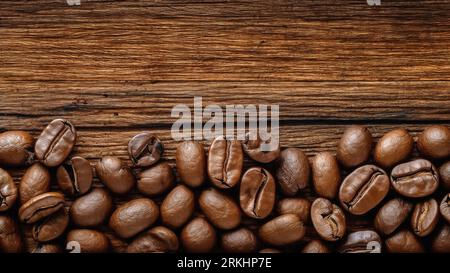 A high-resolution close-up image of roasted coffee beans arranged neatly on a wooden table Stock Photo