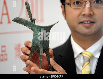 Bildnummer: 55919581  Datum: 08.09.2011  Copyright: imago/Xinhua (110908) -- HONG KONG, Sept. 8, 2011 (Xinhua) -- A staff member presents a 16.5-centimeter-high bronze ritual vessel of ancient China s Shang Dynasty (16th-11th century BC), with an estimated price of over 10 million HK dollars, during a press conference of the Fine Art Aisa 2011 in Hong Kong, south China, Sept. 8, 2011. The Fine Art Asia 2011 will be held in Hong Kong from Oct. 3 to Oct. 7, which is expected to attract more than 100 dealers from Asia, Europe and the United States. More than 5,000 works of art will be exhibited, Foto Stock