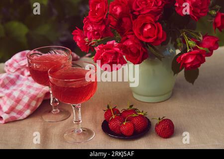 Il cibo estivo e' ancora vivo. Bicchieri di prosecco di fragole spumante rosse, fragole e cioccolato. Tavoli in terrazza. Foto Stock