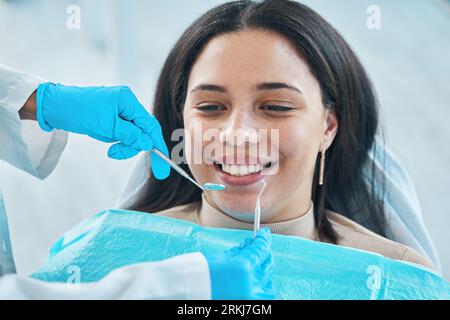 Dentist, hands and patient, woman and teeth whitening, metal tools for dental procedure and healthcare. Smile, tooth decay and veneers treatment Stock Photo