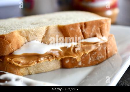 Un panino Fluffernutter fatto con burro di arachidi e crema di marshmallow su un piatto bianco Foto Stock