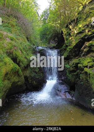 Una maestosa cascata che scende lungo il lato roccioso di una montagna Foto Stock