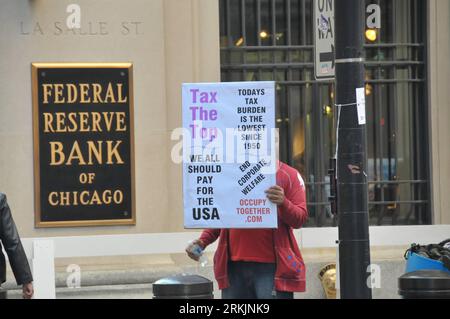 Bildnummer: 56150786 Datum: 05.10.2011 Copyright: imago/Xinhua (111005) -- CHICAGO, 5 ottobre 2011 (Xinhua) -- Un manifestante tiene un cartello fuori dalla Federal Reserve Bank of Chicago a Chicago, negli Stati Uniti, 5 ottobre 2011. Più di 100 manifestanti che protestavano contro l'avidità delle aziende hanno scelto di trascorrere il 13 ° giorno in campeggio fuori dalla Federal Reserve Bank di Chicago mercoledì, nonostante la polizia di Chicago abbia chiesto loro di spostare i loro effetti personali dalla strada fuori dalla banca. (Xinhua/Zhang Baoping) US-OCCUPY CHICAGO-PROTESTA PUBLICATIONxNOTxINxCHN Gesellschaft Demo Protest Wirtschaft Zentra Foto Stock