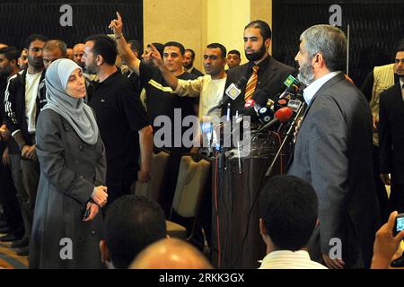 Bildnummer: 56194092 Datum: 18.10.2011 Copyright: imago/Xinhua (111018) -- CAIRO, 18 ottobre 2011, (Xinhua) -- IL leader del movimento Hamas islamico palestinese in esilio Khaled Meshaal (prima destra) parla con una donna durante un incontro con circa 40 prigionieri palestinesi rilasciati da Israele al Cairo, capitale dell'Egitto, il 18 ottobre 2011. Israele e palestinesi hanno concluso martedì la prima fase di un accordo di scambio tra prigionieri raggiunto di recente, che coinvolge il soldato israeliano Gilad Shalit e 1.027 prigionieri palestinesi e arabi, con il sito di scambio principale situato al confine di Rafah tra Egitto e Foto Stock