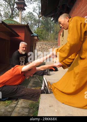 Bildnummer: 56206043  Datum: 21.10.2011  Copyright: imago/Xinhua (111022) -- DENGFENG, Oct. 22, 2011 (Xinhua) -- A Shaolin monk (R) helps German martial arts fans to practise their skills at the Shaolin Temple in Dengfeng City, central China s Henan Province, Oct. 21, 2011. The German visitors came to learn Kung Fu, traditional Chinese martial arts, at the Shaolin Temple, the ancient Chinese monastery famed for its Buddhist traditions and Kung Fu. (Xinhua/Cao Weisong)(ry) CHINA-HENAN-SHAOLIN-KUNG FU-GERMAN (CN) PUBLICATIONxNOTxINxCHN Gesellschaft Kloster Kungfu Ausländer Training Mönch xda x0x Stock Photo