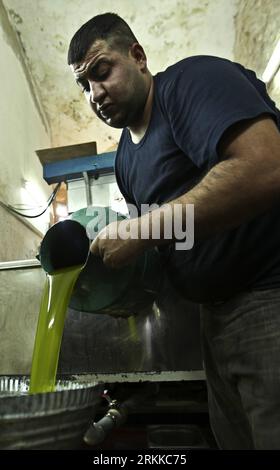 Bildnummer: 56224063  Datum: 27.10.2011  Copyright: imago/Xinhua (111027) -- WEST BANK, Oct. 27, 2011 (Xinhua) -- A Palestinian farmer pours fresh olive oil into a bucket after it was extracted from olives in Silwad village near the West Bank city of Ramallah on Oct. 27, 2011. (Xinhua/Fadi Arouri) MIDEAST-WEST BANK-OLIVE-HARVESTING-SEASON PUBLICATIONxNOTxINxCHN Wirtschaft Landwirtschaft Ernte Olive Olivenernte Palästina Westjordanland x2x xtm 2011 hoch o0 Olivenöl Produktion     56224063 Date 27 10 2011 Copyright Imago XINHUA  WEST Bank OCT 27 2011 XINHUA a PALESTINIAN Farmer pour Fresh Olive Stock Photo