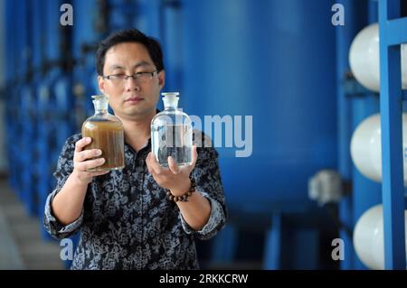 Bildnummer: 56226647  Datum: 22.10.2011  Copyright: imago/Xinhua (111028) -- ZHOUSHAN, Oct. 28, 2011 (Xinhua) -- Technician Zhao Jian displays a bottle of sea water (L) and a bottle of desalination-processed water at a sea water desalination plant in Daishan County of Zhoushan, east China s Zhejiang Province, Oct. 22, 2011. The development of Zhoushan archipelago lies in the bottleneck of the shortage of water supply. Besides the water transported from inland, many islands in Zhoushan are quipped with desalination plants so as to buffer the pain of fresh water shortage. (Xinhua/Ju Huanzong) (h Stock Photo