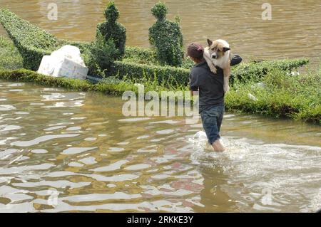 Bildnummer: 56230552 Datum: 30.10.2011 Copyright: imago/Xinhua (111030) -- BANGKOK, 30 ottobre 2011 (Xinhua) -- Un residente locale che porta il suo cane cammina attraverso una strada allagata nel distretto di Thonburi, Bangkok, capitale della Thailandia, 30 ottobre 2011. Un totale di 381 sono stati confermati morti e due erano dispersi nelle peggiori inondazioni della Thailandia che hanno inondato molte province dal luglio 25, ha detto domenica il Dipartimento di prevenzione e mitigazione dei disastri. (Xinhua/Rachen Sageamsak) (lyx) THAILANDIA-BANGKOK-FLOOD PUBLICATIONxNOTxINxCHN Gesellschaft Wetter Regen Naturkatastrophen Hochwasser Unwetter Überflutung xjh Foto Stock