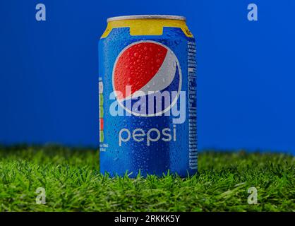 Mansfield, Nottingham, Regno Unito, 25 agosto 2023: Immagine del prodotto Studio di una lattina di Pepsi appoggiata su un'erba con uno sfondo blu. Foto Stock