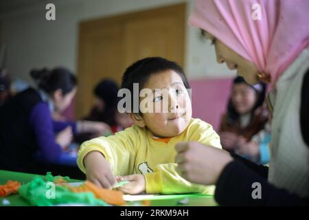 Bildnummer: 56575009 Datum: 25.11.2011 Copyright: imago/Xinhua (111203) -- XINING, 3 dicembre 2011 (Xinhua) -- il quattroenne ma Shaoqian, gruppo etnico Hui, che soffre di problemi uditivi, è visto seduto con sua madre in un corso di educazione al lavoro manuale in un centro di riabilitazione uditiva a Xi Ning, capitale della provincia del Qinghai della Cina nord-occidentale, 25 novembre 2011. Per molti bambini non udenti, l'udito parzialmente compromesso può essere migliorato alla normale capacità grazie all'impianto della coclea e all'uso dell'apparecchio acustico. Negli ultimi cinque anni, la Cina ha lanciato un progetto di riabilitazione gratuito per gli Hearing-los Foto Stock