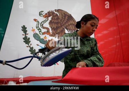 Mexiko Stadt, Messico. 25 agosto 2023. Un membro delle forze armate ironica una bandiera del Messico durante i preparativi per le celebrazioni del 213° giorno dell'indipendenza del paese. Le sfilate cerimoniali si terranno il 15 e 16 settembre. Crediti: Gerardo Vieyra/dpa/Alamy Live News Foto Stock