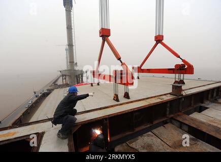 Bildnummer: 56882269 Datum: 13.01.2012 Copyright: imago/Xinhua (120113) -- SHAOXING, 13 gennaio 2012 (Xinhua) -- Una trave scatolata in acciaio del ponte Jiaxing-Shaoxing (Jiashao) è sollevata da una gru sulla baia di Hangzhou, nella provincia dello Zhejiang della Cina orientale, 13 gennaio 2012. Poiché il secondo ponte sul mare che attraversa la baia di Hangzhou, il ponte di Jiashao dovrebbe essere messo in funzione entro la fine del 2012. Dimezzerà il tempo di viaggio a 1,5 ore tra Shaoxing a Zhejiang e Shanghai. (Xinhua/Xu Yu)(wjq)(hdt) CHINA-ZHEJIANG-CROSS SEA BRIDGE-CONSTRUCTION (CN) PUBLICATIONxNOTxINxCHN Wirtschaf Foto Stock