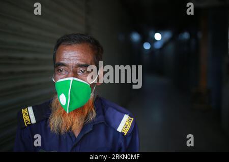 DHAKA, BANGLADESH - MARCH 31, 2020:  A security guard wears face mask inside a market during the nationwide lockdown as a preventive measure against the COVID-19 coronavirus outbreak, in Dhaka, Bangladesh on March 31, 2020. Stock Photo