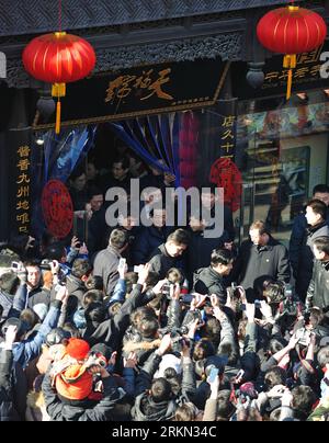 Bildnummer: 56944292  Datum: 22.01.2012  Copyright: imago/Xinhua (120122) -- BEIJING, Jan. 22, 2012 (Xinhua) -- Chinese President Hu Jintao (C) walks out of Tianfuhao, a 270-year-old store famous for braised pork, as he visits the Qianmen shopping street in Beijing, capital of China, Jan. 22, 2012. Hu visited grassroots urban and rural areas in Beijing on Sunday, the eve of the Spring Festival, extending greetings to the and celebrating with them the Chinese Lunar New Year. (Xinhua) (lmm) CHINA-BEIJING-HU JINTAO-VISIT (CN) PUBLICATIONxNOTxINxCHN People Politik Frühlingsfest Neujahrsfest xda x0 Stock Photo