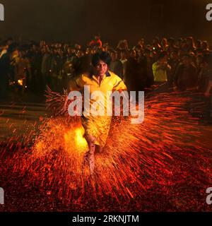 Bildnummer: 57211814  Datum: 04.03.2012  Copyright: imago/Xinhua (120305) -- LEIZHOU, March 5, 2012 (Xinhua) -- A villager runs barefoot past a bonfire to pray for good fortune in Binhe Village, Liezhou City of south China s Guangdong Province, March 4, 2012. Local villagers step on fire to showcase their courage and pray for good luck in such a traditional activity. (Xinhua/Cai Cheng) (lfj) CHINA-GUANGDONG-LEIZHOU-TRADITION (CN) PUBLICATIONxNOTxINxCHN Gesellschaft xbs x2x 2012 quadrat o0 Kurios, Feuer glühende Kohlen Kohle Laufen Barfuss o00 Funken     57211814 Date 04 03 2012 Copyright Imago Stock Photo