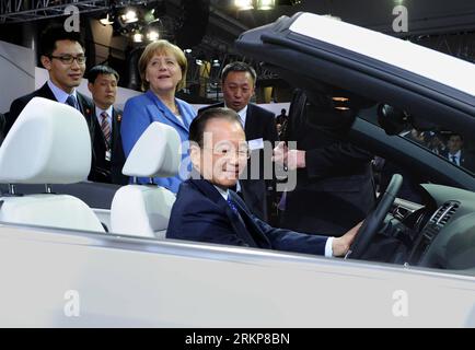 120423 -- HANNOVER, 23 aprile 2012 Xinhua -- fronte del Premier cinese Wen Jiabao, accompagnato dalla cancelliera tedesca Angela Merkel 3rd L Back, prova un veicolo presso la sede della Volkswagen a Wolfsburg, Germania, 23 aprile 2012. Xinhua/Rao Aimin hdt GERMANY-CHINA-WEN JIABAO-VOLKSWAGEN-VISIT PUBLICATIONxNOTxINxCHN Foto Stock