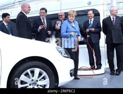 120423 -- HANNOVER, 23 aprile 2012 Xinhua -- il Premier cinese Wen Jiabao 2nd R e il cancelliere tedesco Angela Merkel 3rd R tengono i cavi di alimentazione durante una dimostrazione per la ricarica di auto elettriche, mentre visitano il quartier generale della Volkswagen a Wolfsburg, Germania, 23 aprile 2012. Xinhua/Pang Xinglei hdt GERMANY-CHINA-WEN JIABAO-VOLKSWAGEN-VISIT PUBLICATIONxNOTxINxCHN Foto Stock