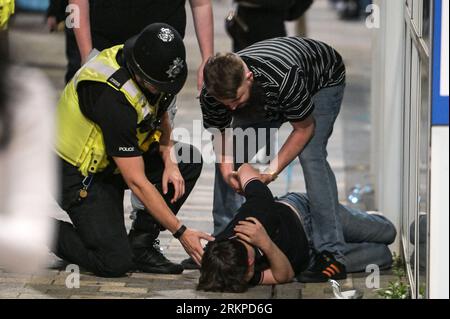 Broad Street, Birmingham, 26 agosto 2023 - controllo della polizia per vedere se un ragazzo sta bene dopo essere caduto a Birmingham. - I rivenditori sono scesi sulla Broad Street di Birmingham venerdì sera per godersi l'ultimo fine settimana delle festività nazionali fino a Natale. La maggior parte dei festaioli indossava abiti magri nonostante le temperature calassero rispetto all'inizio della settimana. Grandi code si formarono all'esterno dei locali notturni, tra cui PRYZM, Rosies e Popworld. Gruppi di amici hanno posato per una foto mentre il festeggiava la notte. Credito: Stop Press Media/Alamy Live News Foto Stock