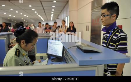 120712 -- HOHHOT, July 12, 2012 Xinhua -- A checkpoint staff member helps a passenger on entry procedures in Baita International Airport in Hohhot, north China s Inner Mongolia Autonomous Region, July 12, 2012. More than 170 passengers arrive at the Airpot on 12:55 Thursday. The Air Macao flight numbered NX9071 is the first tourist charter flight from Macao to Inner Mongolia. Xinhua/Zhao Tingting wjq CHINA-INNER MONGOLIA-HOHHOT-MACAO-AIRLINE CN PUBLICATIONxNOTxINxCHN Stock Photo