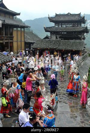 Bildnummer: 58275467  Datum: 24.07.2012  Copyright: imago/Xinhua (120724) -- KAILI, July 24, 2012 (Xinhua) -- Tourists wearing clothing of the Miao ethnic group take pictures at Xijiang Ethnic Miao Stockaded Village of Qiandongnan Miao and Dong Autonomous Prefecture, southwest China s Guizhou Province, July 24, 2012. The Xijiang Stockaded Village of Ethnic Miao, with over a thousand households living in community, is a notable tourist attraction for its prominent features of Ethnic Miao s folk custom and appeal. (Xinhua/Wang Song) (wjq) CHINA-GUIZHOU-KAILI-FOLK CUSTOM OF ETHNIC MIAO (CN) PUBLI Stock Photo