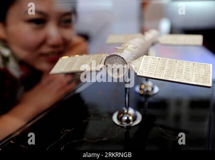 Bildnummer: 58283783  Datum: 27.07.2012  Copyright: imago/Xinhua (120727) -- SHENYANG, July 27, 2012 (Xinhua) -- A visitor looks at a silver model of the docking Shenzhou-9 space craft and Tiangong-1 space lab module at the International Jewelry Show in Shenyang, capital of northeast China s Liaoning Province, July 27, 2012. More than 300 exhibitors from home and abroad attended the four-day International Jewelry Show in Shenyang, which kicked off on Friday. (Xinhua/Zhang Wenkui) (llp) CHINA-SHENYANG-JEWELRY SHOW (CN) PUBLICATIONxNOTxINxCHN Gesellschaft Wirtschaft Schmuck Schmuckmesse Messe xd Stock Photo