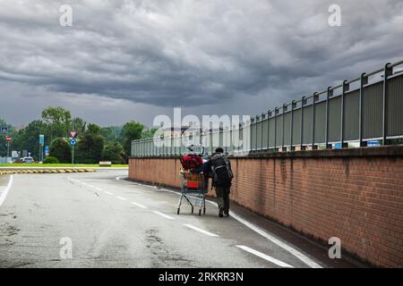 i senzatetto spingono il carrello della spesa per strada Foto Stock