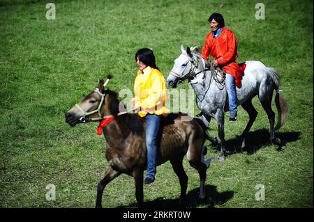 Bildnummer: 58302593  Datum: 02.08.2012  Copyright: imago/Xinhua (120802) -- QINGHAI, Aug. 2, 2012 (Xinhua) -- Two riders prepare for a horse racing competition during the Nadam fair in Henan Mongolian Autonomous County of Huangnan Tibetan Autonomous Prefecture, northwest China s Qinghai Province, Aug. 2, 2012. Nadam, meaning entertainment and playing in Mongolian language, is a folk festival of the Mongolian ethnic group. During the three-day event, local residents will participate in activities like horse racing and Mongolian wrestling. (Xinhua/Zhang Hongxiang) (cl) CHINA-QINGHAI-NADAM (CN) Stock Photo