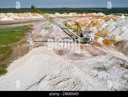 Il dragline a piedi con paranco e benna lavora in cava di pietra Foto Stock