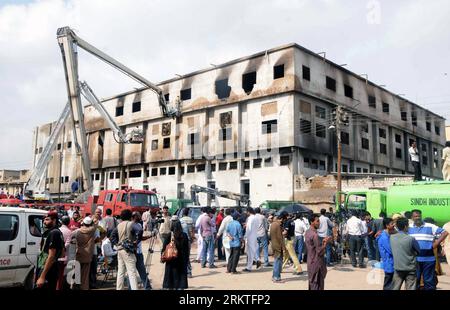 (120913) -- KARACHI, 13 settembre 2012 (Xinhua) -- i soccorritori pakistani si riuniscono all'interno di una fabbrica di indumenti a seguito di un incendio nella città portuale del sud pakistano di Karachi il 13 settembre 2012. Il bilancio delle vittime di un incendio scoppiato in una fabbrica di abbigliamento nella città portuale meridionale del Pakistan di Karachi martedì sera ha raggiunto i 289. (Xinhua Photo/Arshad) (zkr) PAKISTAN-KARACHI-FACTORY FIRE PUBLICATIONxNOTxINxCHN Foto Stock