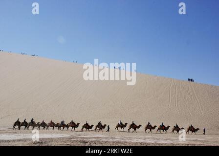 Bildnummer: 58551537 Datum: 04.10.2012 Copyright: imago/Xinhua (121004) -- DUNHUANG, 4 ottobre 2012 (Xinhua) -- i turisti cavalcano i cammelli nel punto panoramico del lago Crescent nella città di Dunhuang, provincia del Gansu della Cina nord-occidentale, 4 ottobre 2012. Dunhuang, una tappa importante sull'antica via della Seta, famosa per le sue grotte di Mogao (Grotte di 1.000 Buddha), il Lago della Mezzaluna e il Monte Mingsha, ha attirato un gran numero di turisti sia dalla patria che dall'estero durante la festa nazionale. (Xinhua/Zhang Xiaoliang) (mp) CHINA-GANSU-DUNHUANG-TOURISM (CN) PUBLICATIONxNOTxINxCHN Gesellschaft Tourismus Seidenstrasse L. Foto Stock