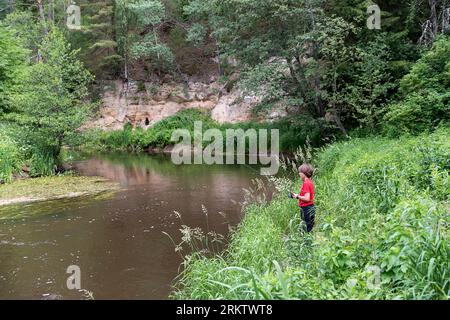 Pesca per ragazzi in un piccolo e bellissimo fiume di Vohandu nella zona di Suvahavva, nella parte meridionale dell'Estonia Foto Stock
