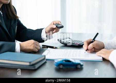 Closeup donne asiatiche persone auto saler o responsabile vendite offre di vendere un'auto e spiega e legge i termini della firma di un contratto di auto e di un'assicurazione. Foto Stock