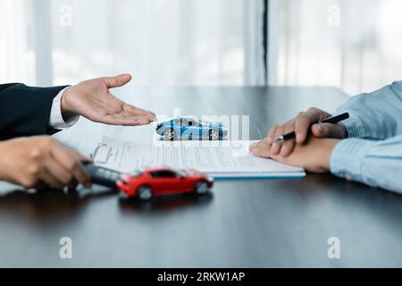 Closeup donne asiatiche persone auto saler o responsabile vendite offre di vendere un'auto e spiega e legge i termini della firma di un contratto di auto e di un'assicurazione. Foto Stock