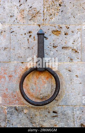 Antico anello di ferro per legare i cavalli sul muro di pietra, Siena Toscana Italia Foto Stock