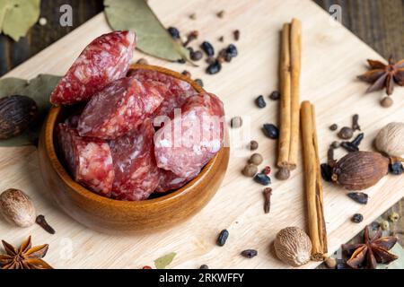 Salsiccia di vitello essiccata durante l'affettatura, preparazione di snack da salsiccia di vitello essiccata Foto Stock