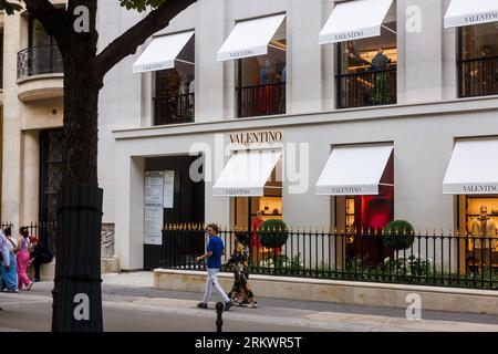 A Valentino store in Paris with people walking nearby Stock Photo