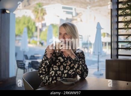 Donna di bere il caffè della mattina al ristorante Foto Stock