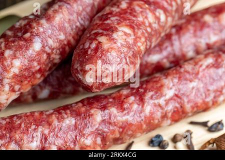 Salsiccia di vitello essiccata durante l'affettatura, preparazione di snack da salsiccia di vitello essiccata Foto Stock