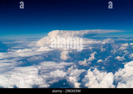 Vista delle nuvole bianche di forma astratta dalla finestra dell'aereo Foto Stock