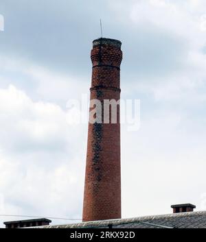 Tubo industriale in mattoni isolato su sfondo cielo bianco Foto Stock