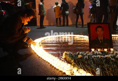 Bildnummer: 58971276 Datum: 07.01.2013 Copyright: imago/Xinhua Una donna accende le candele durante un servizio commemorativo per i tre vigili del fuoco che sono morti mentre stavano spegnendo il fuoco in una fabbrica di fiamme, a Wushan Square a Hangzhou, capitale della provincia dello Zhejiang della Cina orientale, 7 gennaio 2013. I cittadini locali si sono riuniti qui lunedì sera per piangere i tre vigili del fuoco che hanno sacrificato la loro vita mentre spendevano un incendio nel distretto Xiaoshan di Hangzhou, sei giorni dopo lo scoppio dell'incendio. I tre vigili del fuoco, Yin Jinliang, Chen Wei e Yin Zhihui, furono ratificati come martiri e premiati con medaglie d'oro f Foto Stock