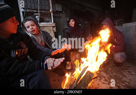 Bildnummer: 59014476 Datum: 10.01.2013 Copyright: imago/Xinhua (130110) -- GAZA, 10 gennaio 2013 (Xinhua) -- i bambini palestinesi si riscaldano davanti a un incendio in un laboratorio nella città di Gaza il 10 gennaio 2013. Dall'8 gennaio piove pesantemente in Cisgiordania e nella Striscia di Gaza. (Xinhua/Yasser Qudih) (dzl) MIDEAST-GAZA-RAIN PUBLICATIONxNOTxINxCHN Gesellschaft Winter Jahreszeit Feuer Kälte Armut Kind x0x xac 2013 quer 59014476 Data 10 01 2013 Copyright Imago XINHUA Gaza 10 gennaio 2013 i bambini PALESTINESI XINHUA si riscaldano da un incendio IN un workshop nella città di Gaza IL 10 gennaio 2013 dall'8 gennaio Foto Stock