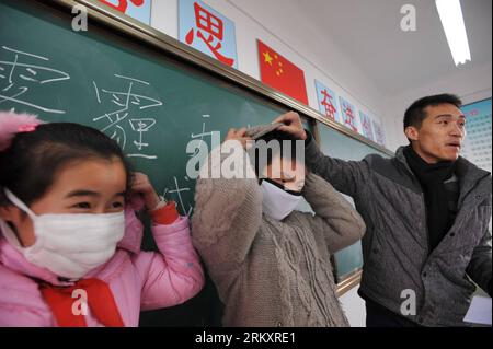 Bildnummer: 59075806 Datum: 14.01.2013 Copyright: imago/Xinhua (130114) -- HEFEI, 14 gennaio 2013 (Xinhua) -- due studenti mostrano di indossare maschere sotto la guida di un insegnante in una classe di educazione fisica al chiuso, poiché le attività sportive all'aperto per le scuole primarie e medie sono state interrotte a causa del forte inquinamento atmosferico nella scuola elementare Hupo Shanzhuang di Hefei, capitale della provincia di Anhui della Cina orientale, 14 gennaio 2013. Le misure di risposta alle emergenze sono state adottate in molte città cinesi, dove l'aria ha mantenuto livelli eccessivi di sostanze inquinanti importanti negli ultimi giorni a causa di un prolungato f Foto Stock