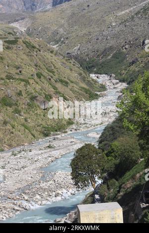 Paesaggio del fiume rurale e della valle fino al villaggio, sfondo della riva del fiume localizzato vicino a Uttrakhand, India, focalizzato con sfocatura Foto Stock