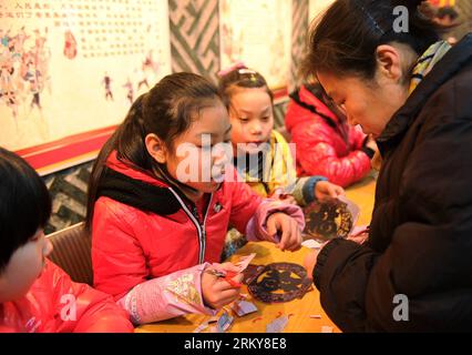 Bildnummer: 59165020 Datum: 03.02.2013 Copyright: imago/Xinhua (130203) -- SHIJIAZHUANG, 3 febbraio 2013 (Xinhua) -- Un cittadino impara a tagliare la carta al Museo delle arti popolari di Shijiazhuang, capitale della provincia di Hebei, 3 febbraio 2013. Gli alunni della scuola primaria di Weitong sono stati invitati il 3 febbraio per presentare le incisioni di carta al museo per salutare il prossimo Festival di Primavera, che cade il 10 febbraio di quest'anno. (Xinhua/Zhu Xudong) (zc) CHINA-HEBEI-SHIJIAZHUANG-PAPER-CUTTING (CN) PUBLICATIONxNOTxINxCHN Gesellschaft Basteln Papier Scherenschnitt x0x xmb 2013 quer 59165020 Data 03 02 Foto Stock