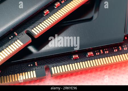 Moduli di memoria DDR4 DRAM con luce rossa. Chip RAM per computer con contatti dorati, primo piano dell'hardware. Componenti di memoria del PC desktop Foto Stock